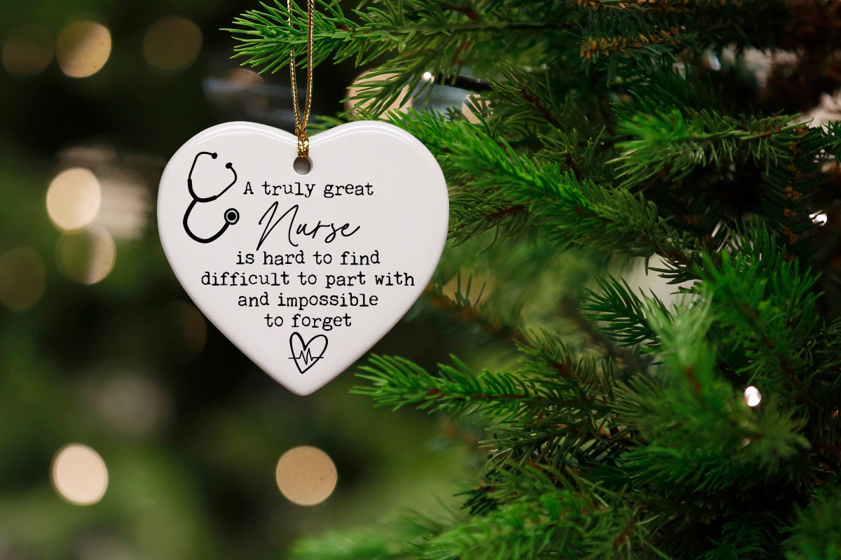 Heart-shaped ornament with a message about a nurse hanging on a Christmas tree.