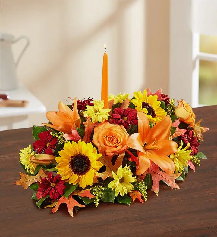 Colorful floral arrangement with a candle on a wooden surface