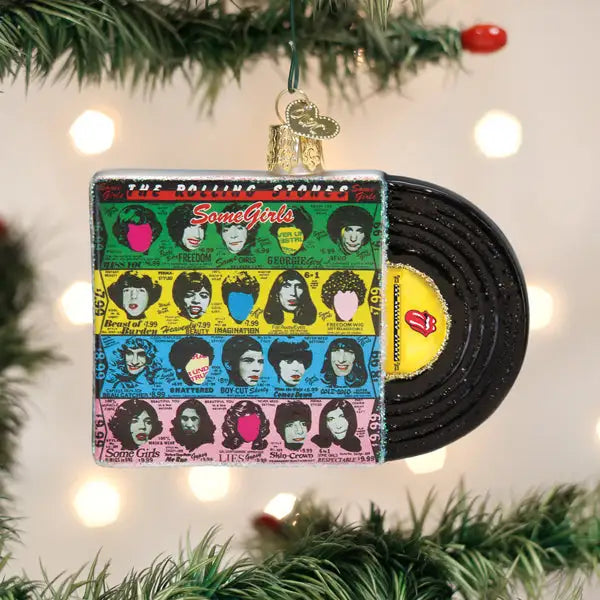 Vinyl record ornament with colorful label featuring faces, hanging on a Christmas tree.