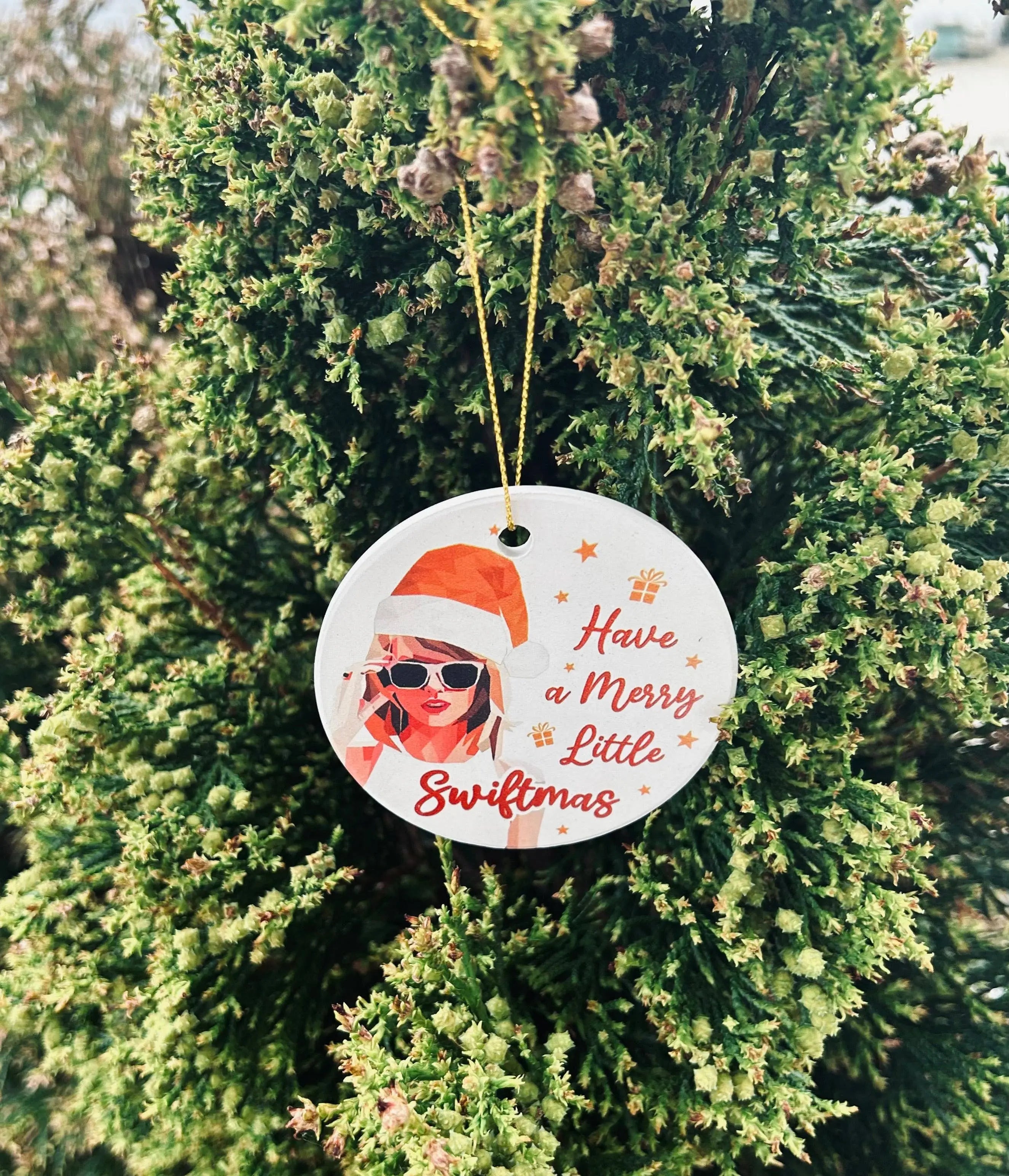 Round Christmas ornament with a festive design hanging on a tree.