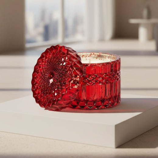 Red glass candle with textured design on a white background