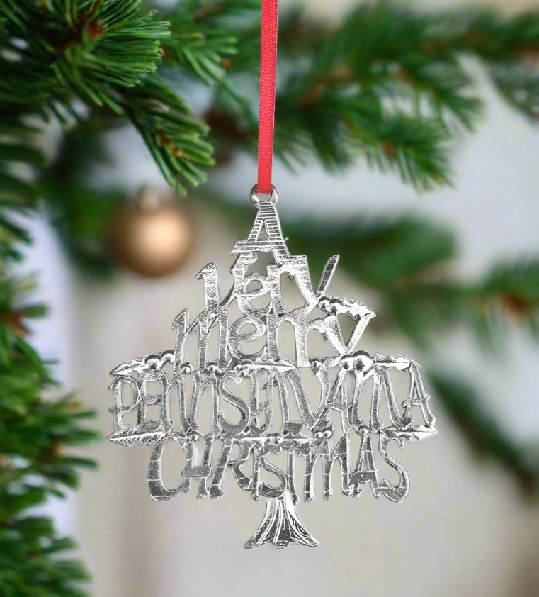 Silver Christmas tree ornament with 'Merry Christmas' text on a blurred Christmas tree background