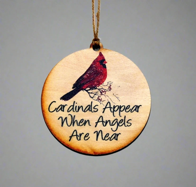 Wooden ornament with cardinal illustration and text on a gray background