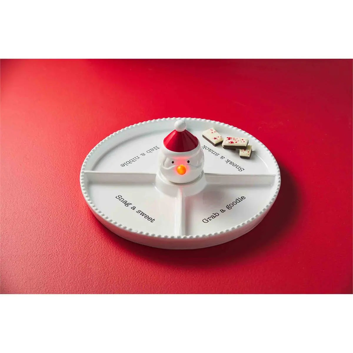 Round white plate with a snowman design on a red background