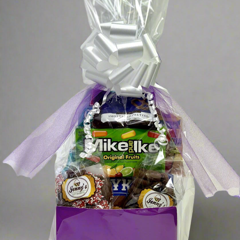 Gift basket with purple box and clear cellophane cover on a gray background