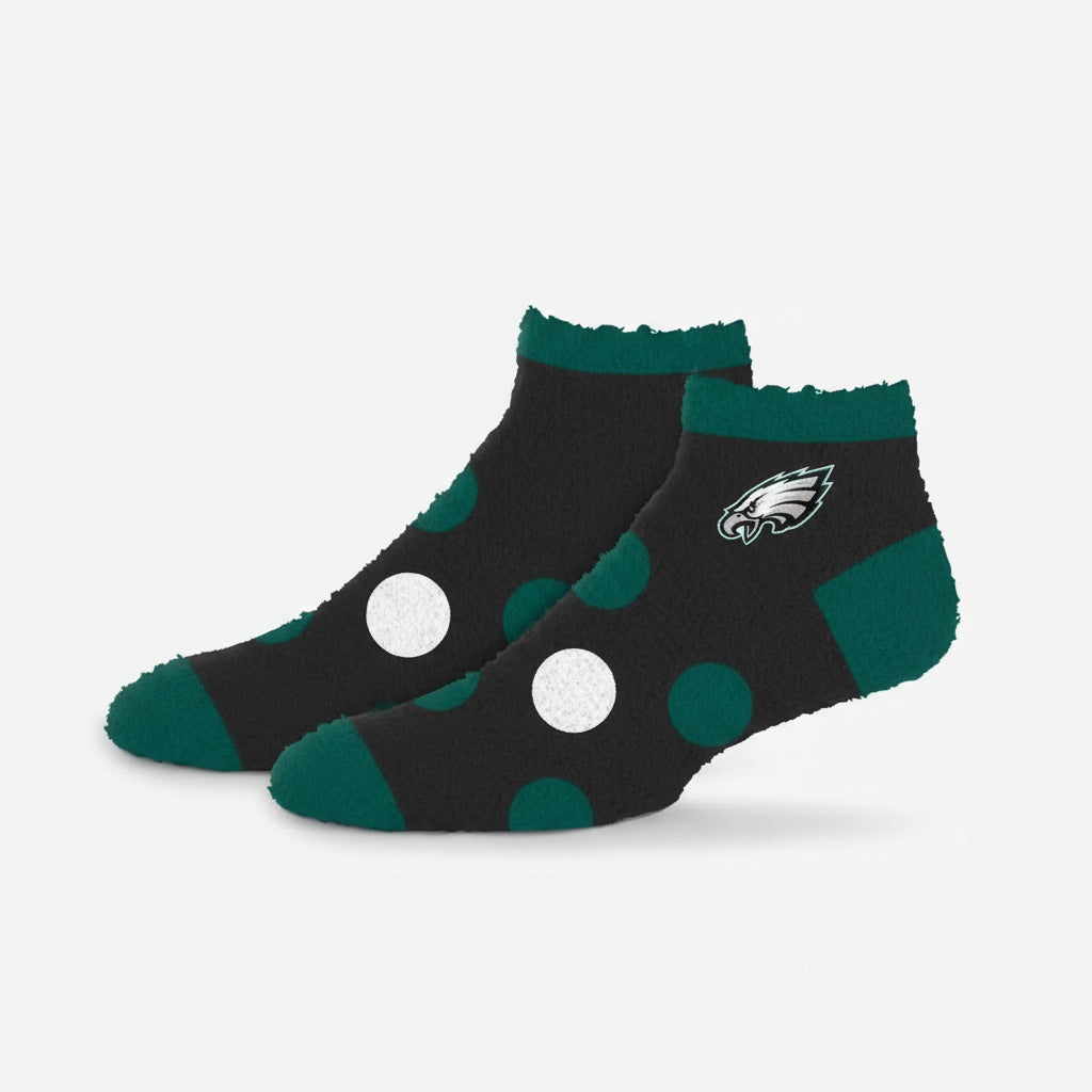 Black socks with green accents and white polka dots on a white background