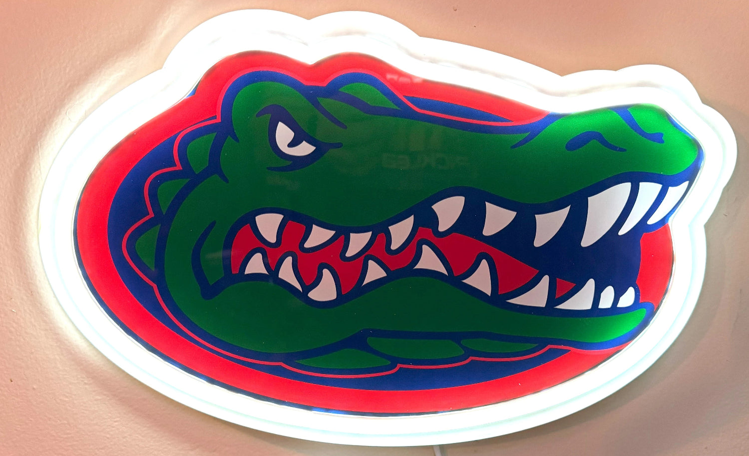 Gator head logo on a wall with a glass of beer in the background