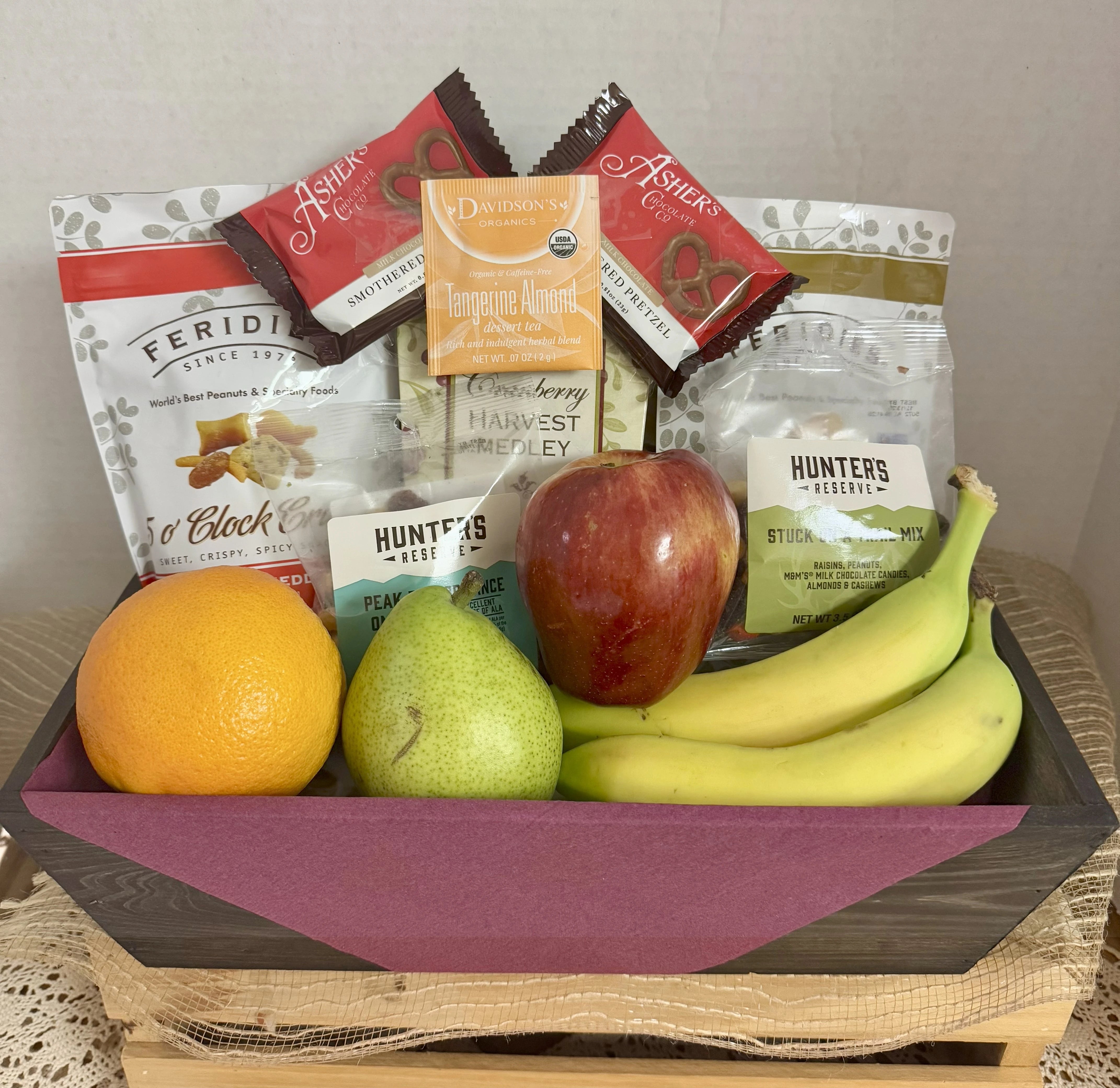 Gift basket with snacks and fruits on a white background