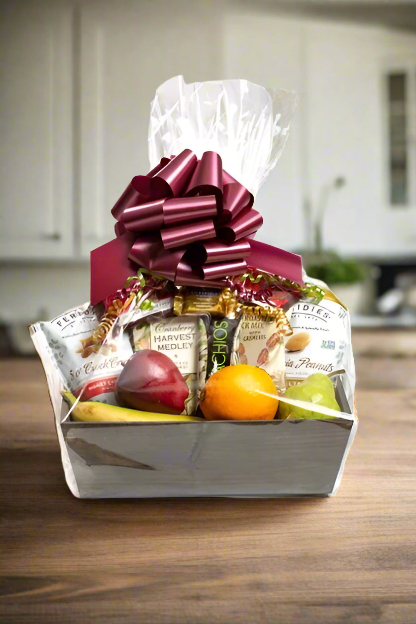 Gift basket with snacks and fruits on a white background