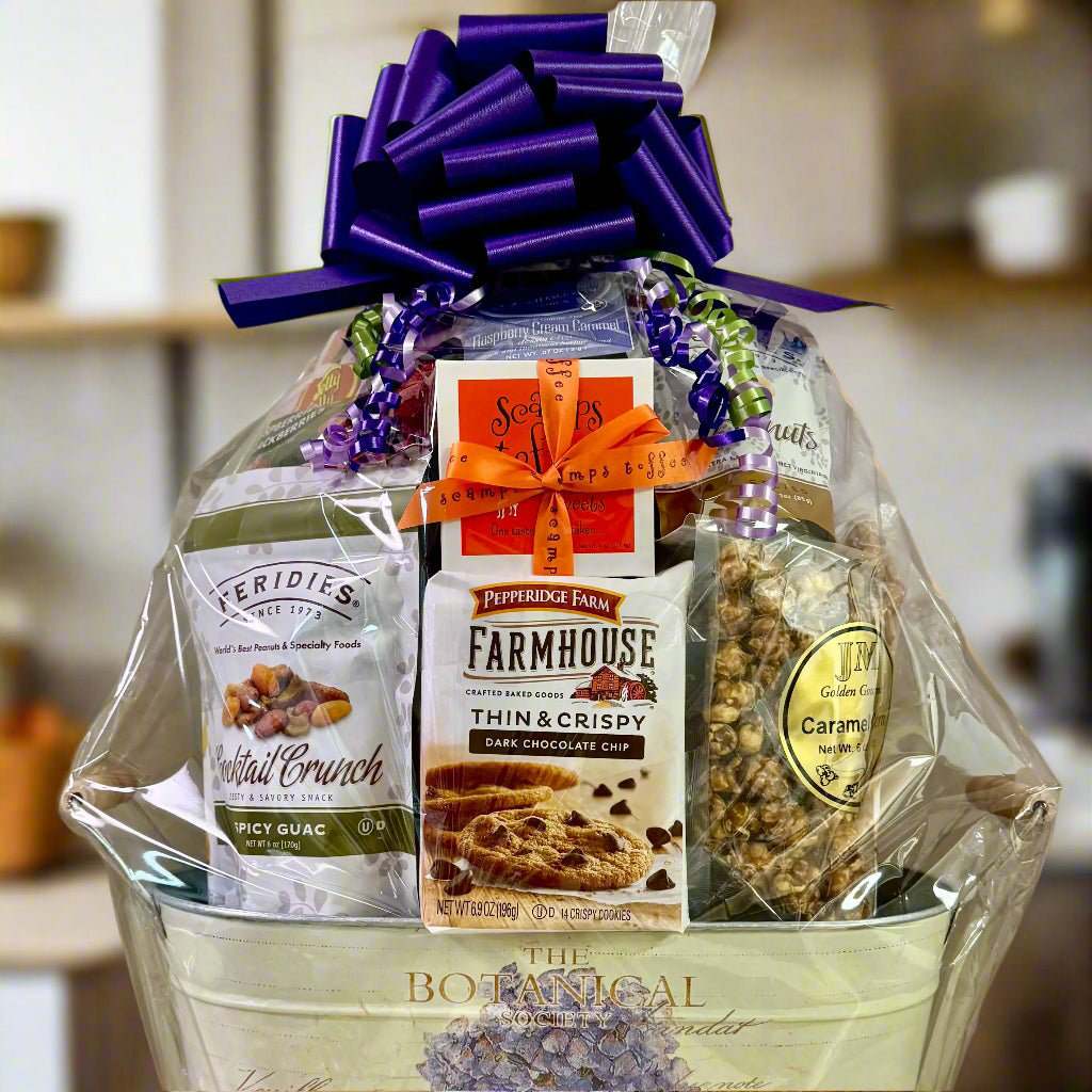 Gift basket with snacks and a purple bow on a neutral background