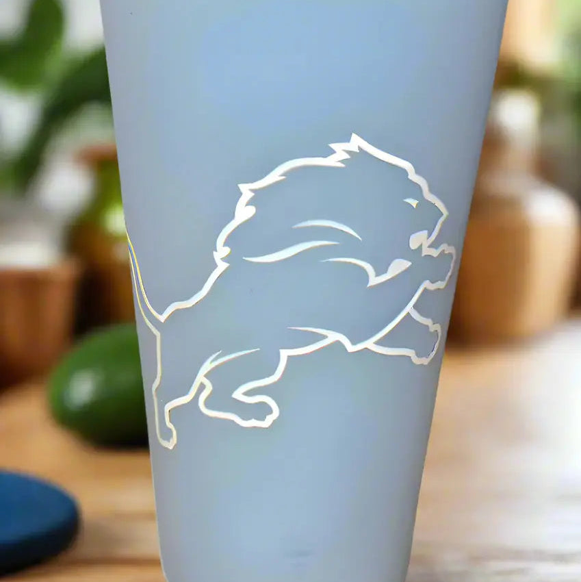 Light blue tumbler with white lion design on a wooden surface