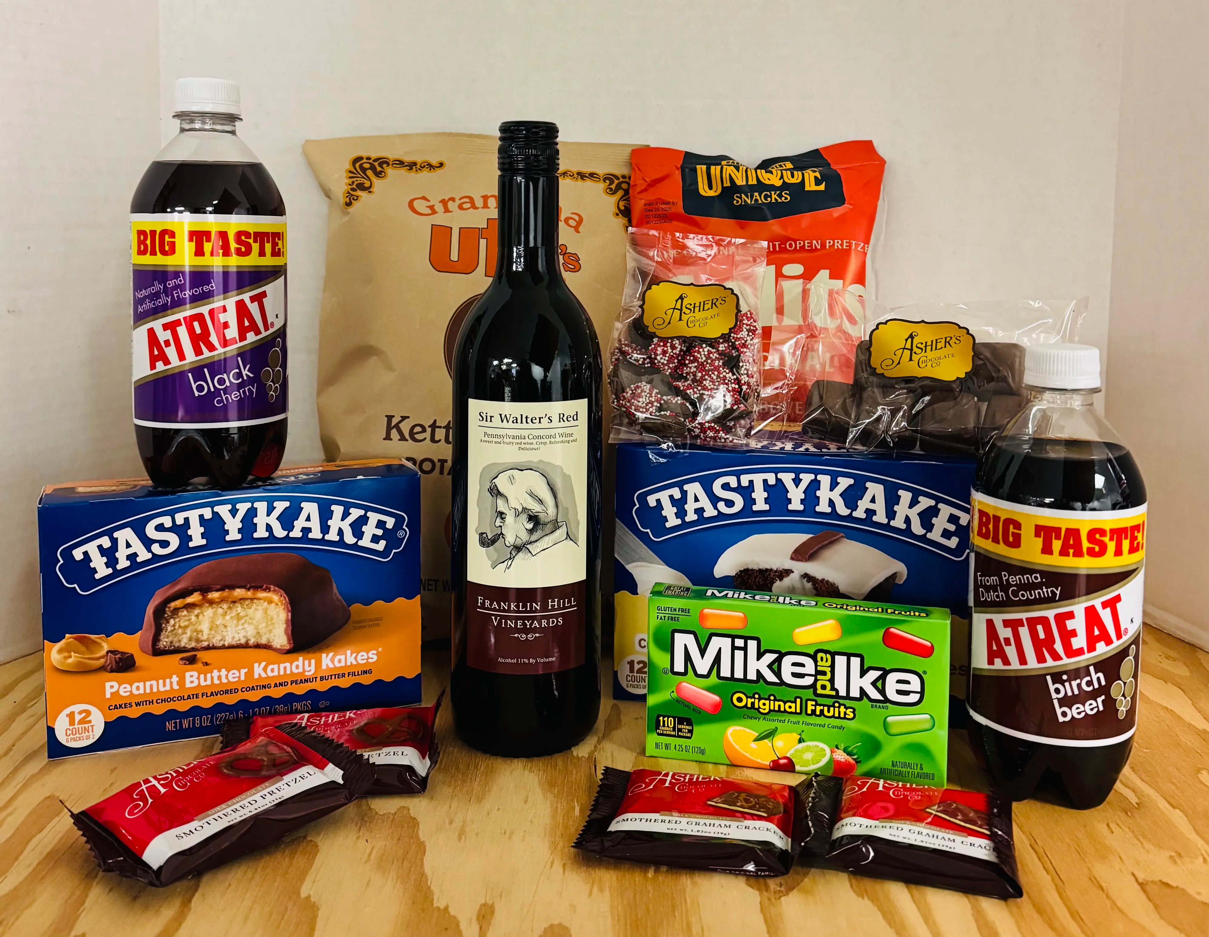 Gift basket with snacks and drinks on a wooden surface
