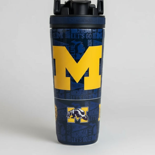 Tumbler with Michigan logo on a wooden surface with greenery