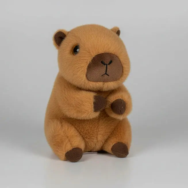 Plush toy resembling a beaver on a wooden floor with a white wall background