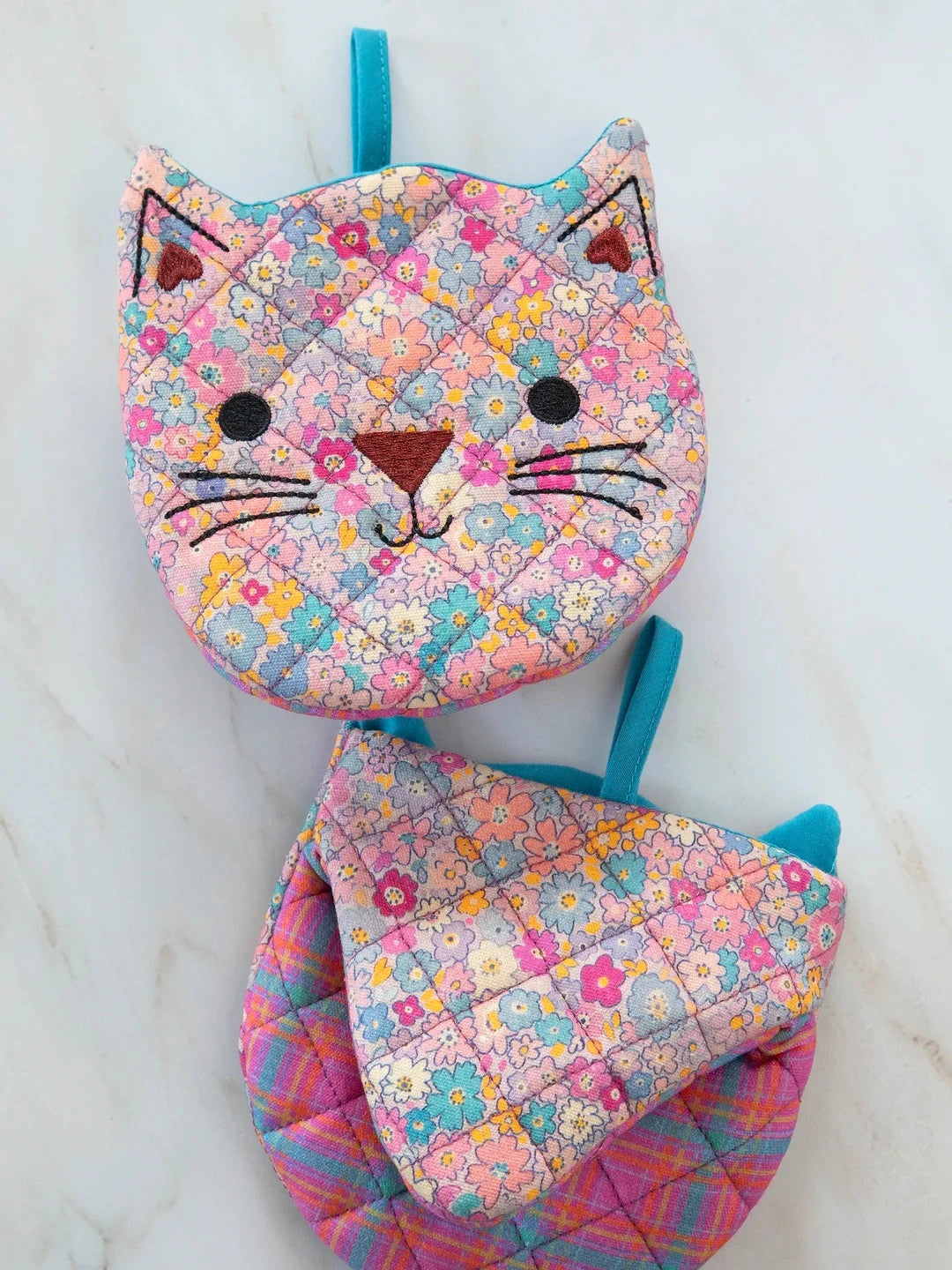 Floral-patterned cat-shaped bag on a marble surface