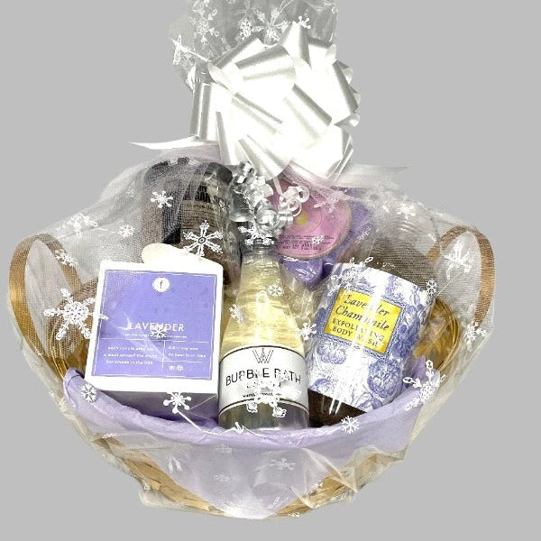 Bouquet of bath products including bottles and a bar of soap, wrapped with decorative ribbons and snowflake decorations on a gray background.