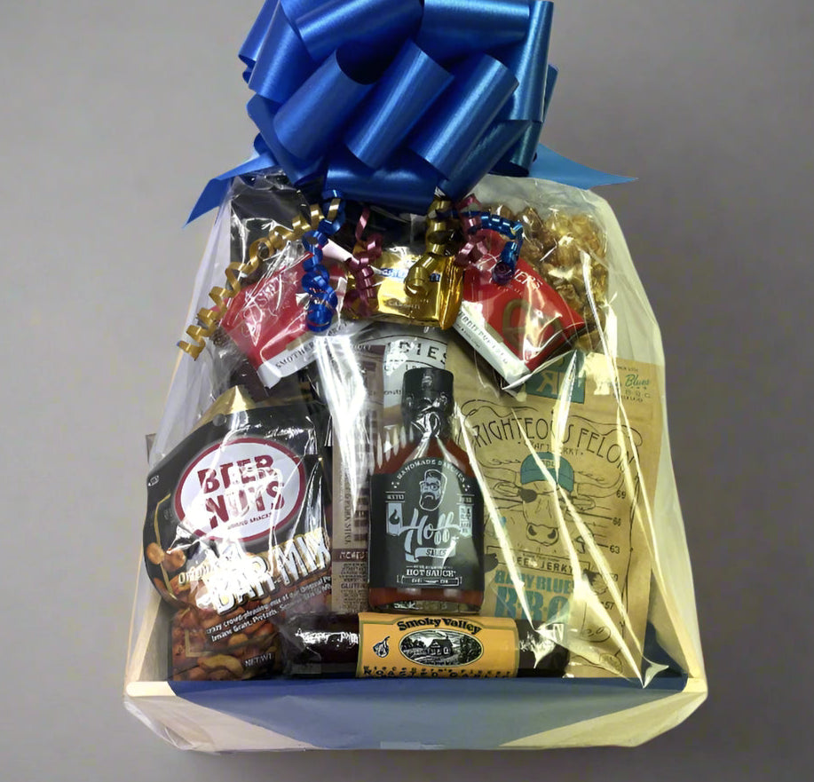 Gift basket with snacks and drinks on a gray background