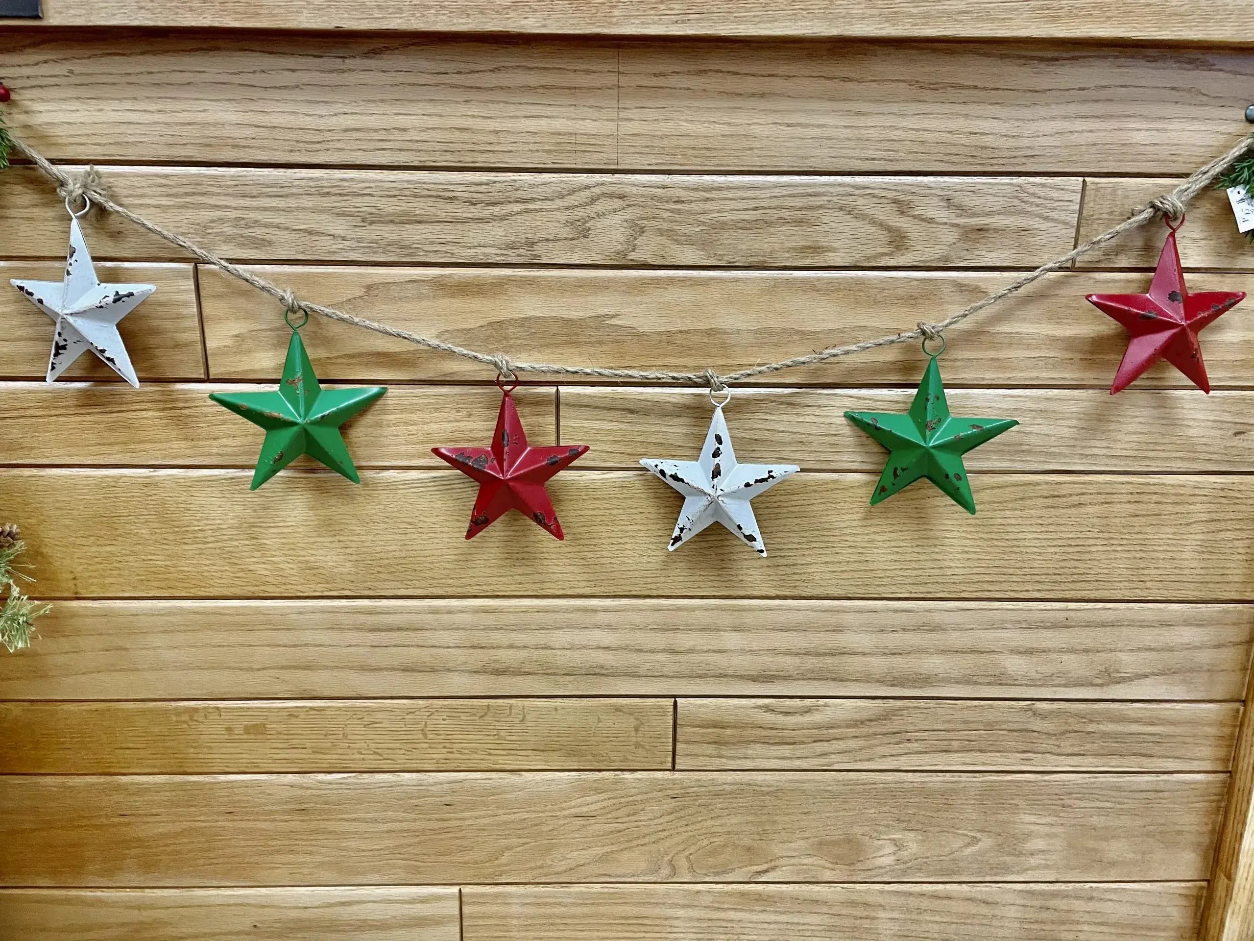 String of colorful star-shaped ornaments on a wooden wall