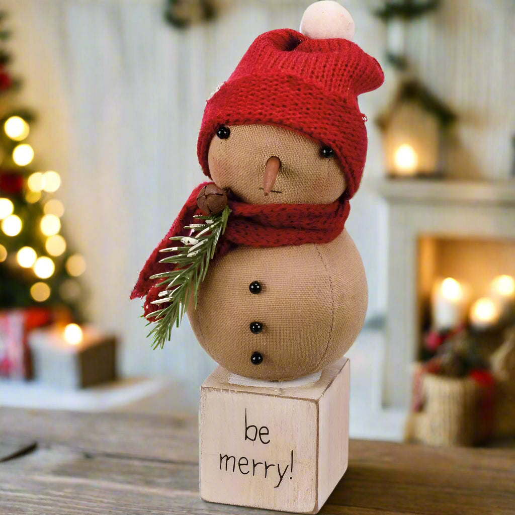 Decorative snowman figurine with red hat and scarf on a white background