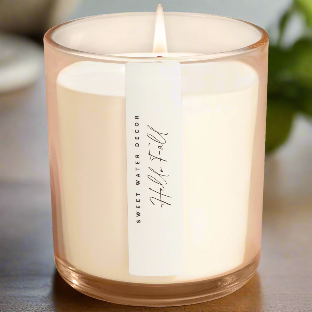 Candle in a clear glass jar with a label on a white background