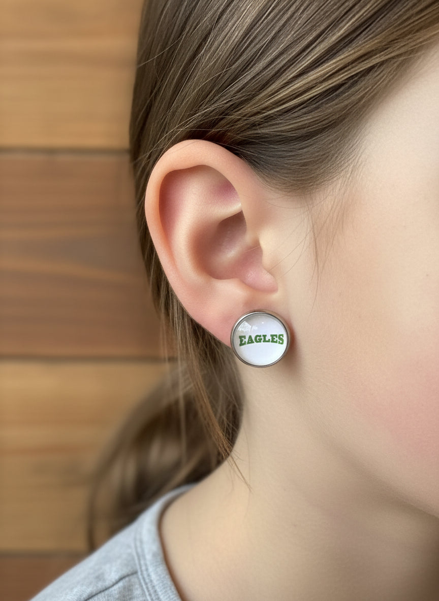 Pair of earrings on a 'The Philly Sports Girl' branded card against a wooden background