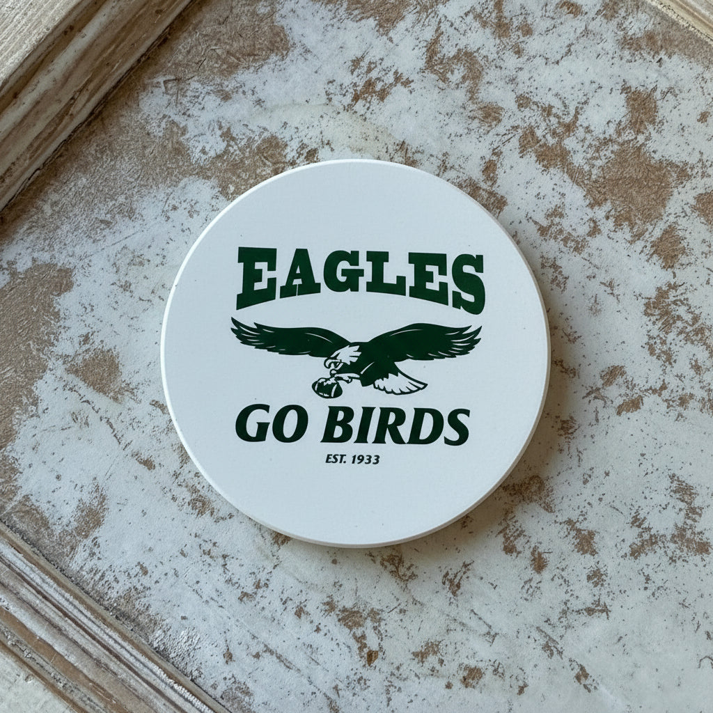 Two coasters with eagle designs on a textured surface