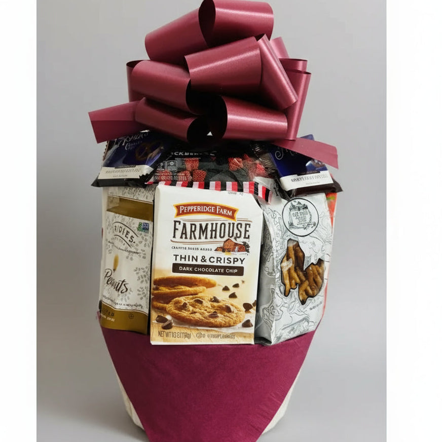 Gift basket with a large red bow containing snacks and cookies on a neutral background