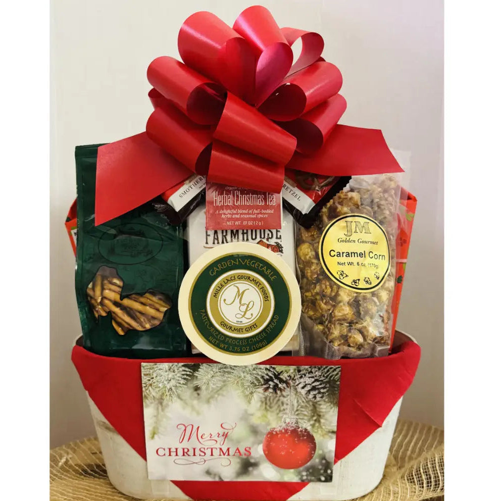 Gift basket with a red bow, including snacks and a cheese block, on a white background.