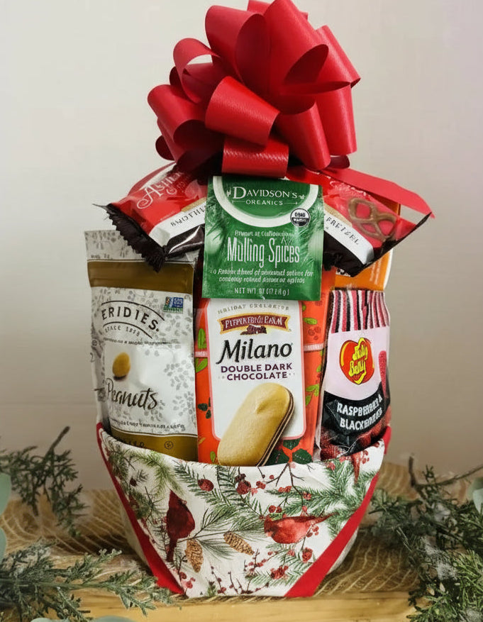 Gift basket with assorted snacks and a gold bow on a neutral background