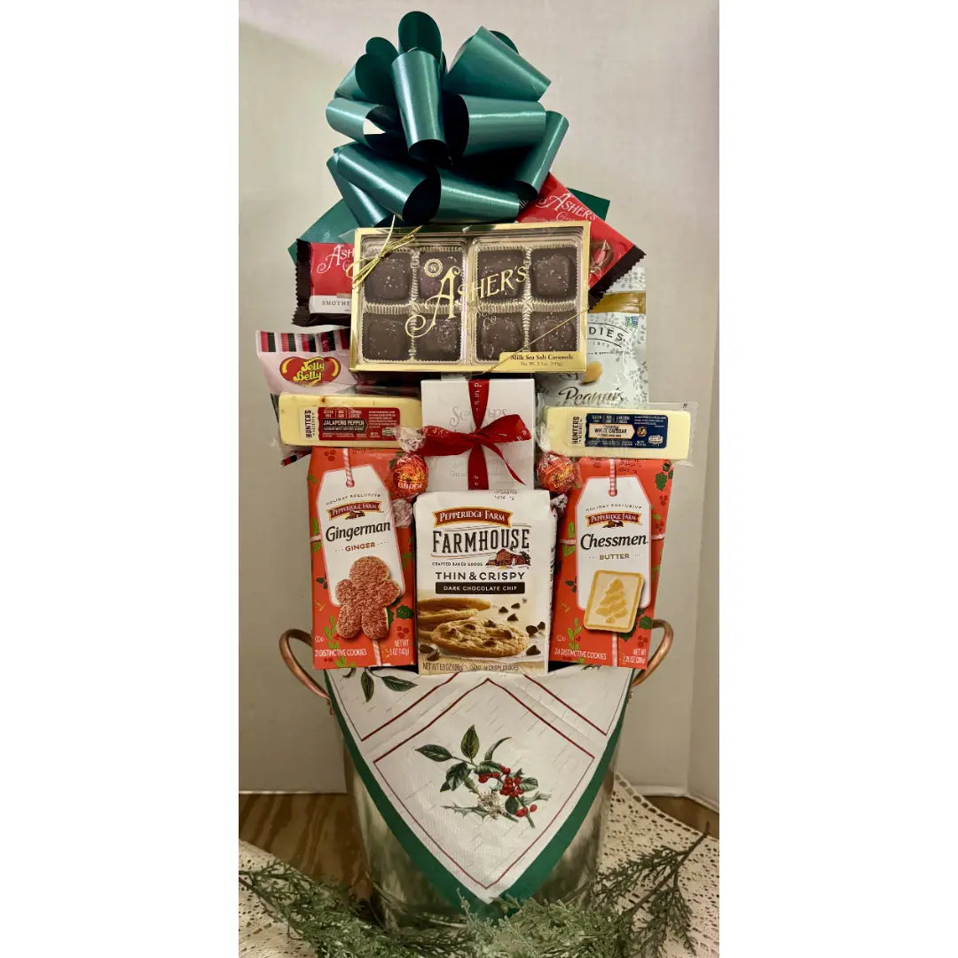Gift basket with various items including chocolate, cookies, and a bow on a white background
